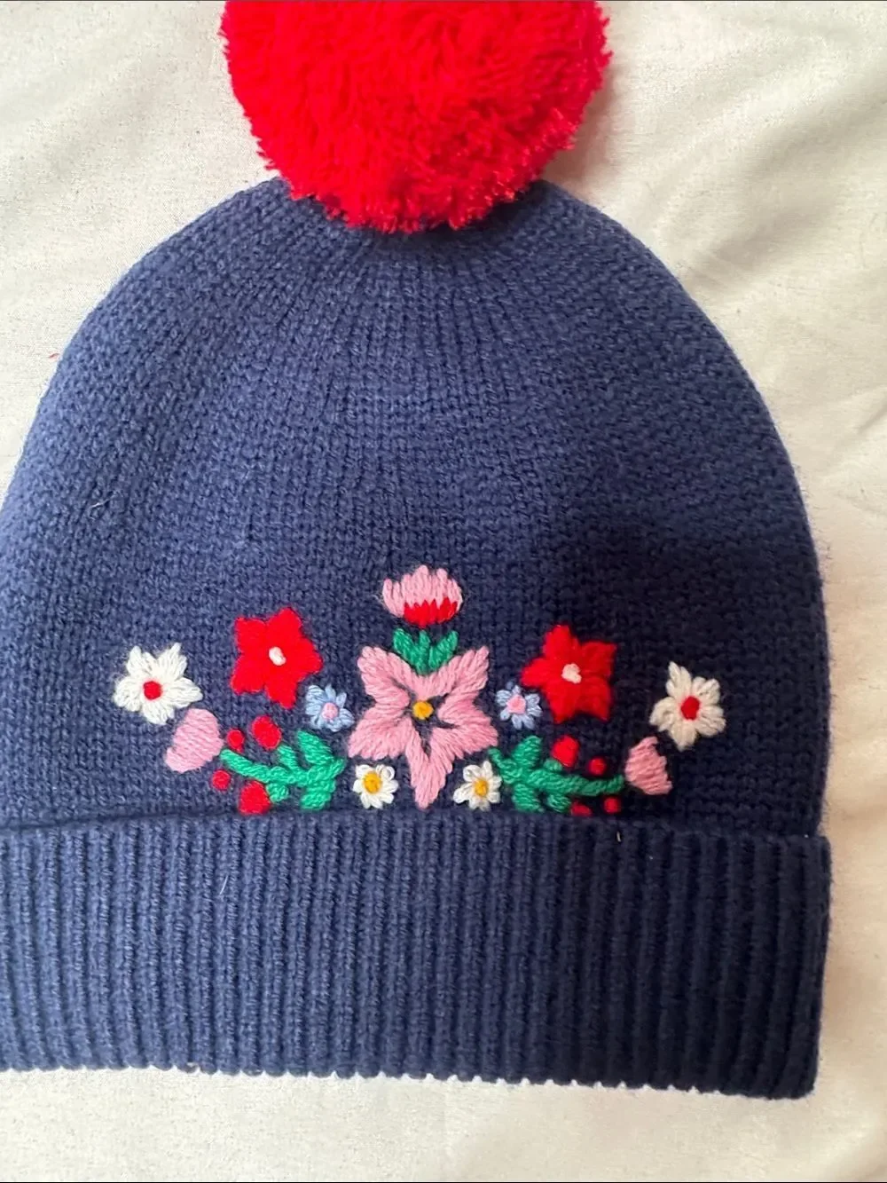 Mini Boden Navy Knit Beanie with Red Pom & Floral Embroidery. Size 2-4 years.